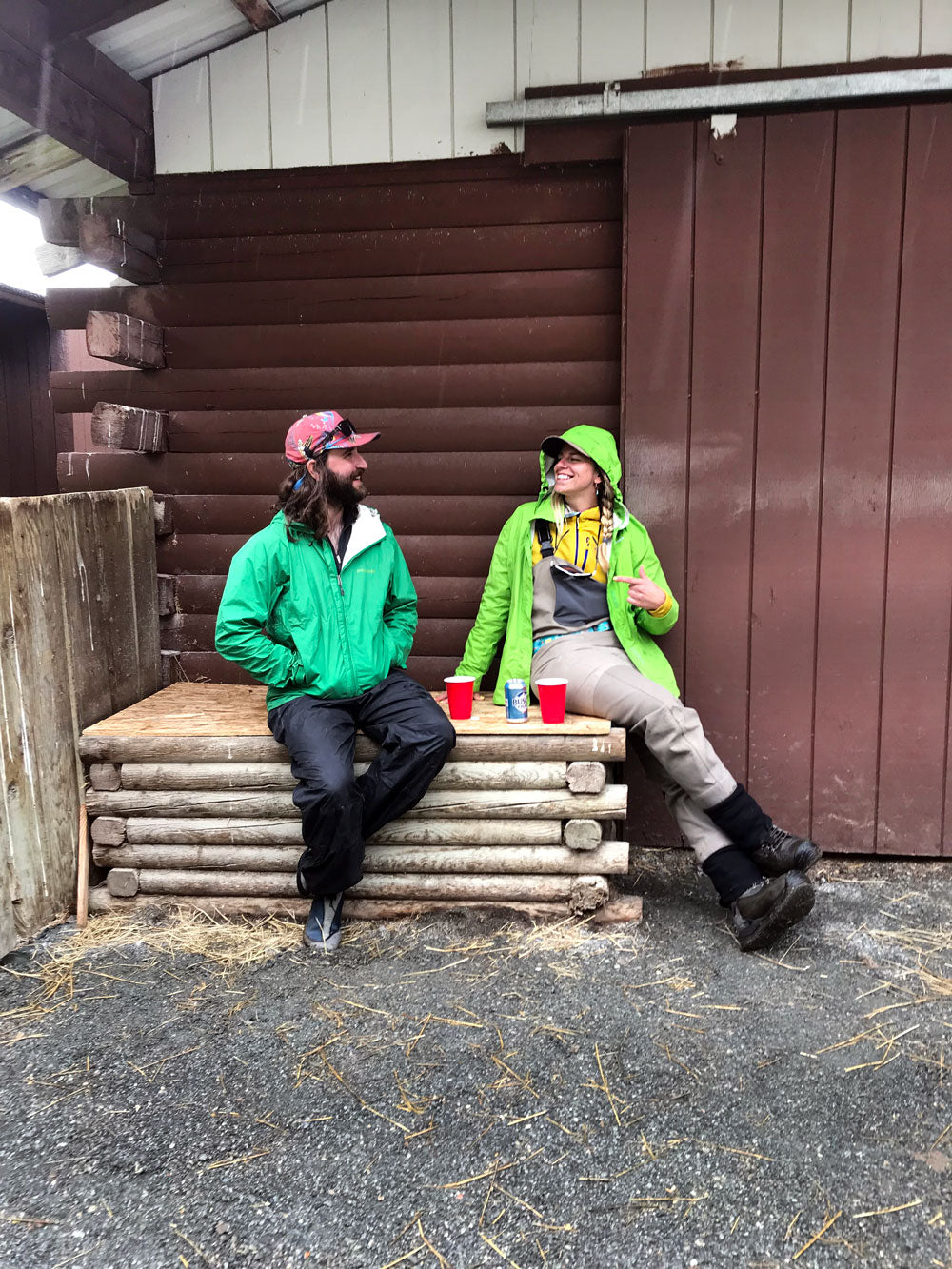 Two people sitting in front of a barn having a conversation
